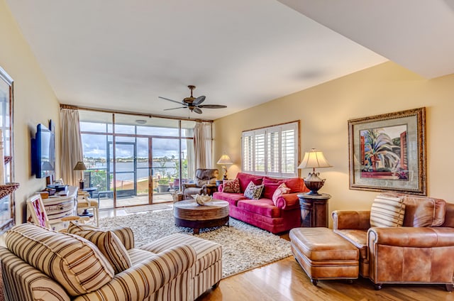 living room featuring hardwood / wood-style flooring, expansive windows, and ceiling fan