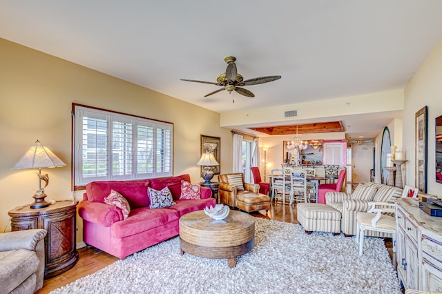 living room featuring hardwood / wood-style flooring and ceiling fan with notable chandelier