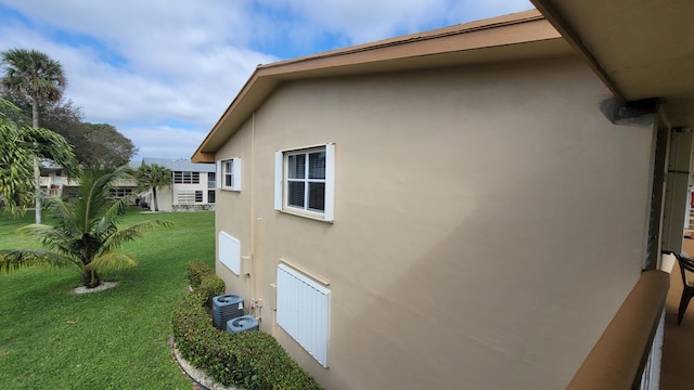 view of side of home featuring a lawn and central air condition unit