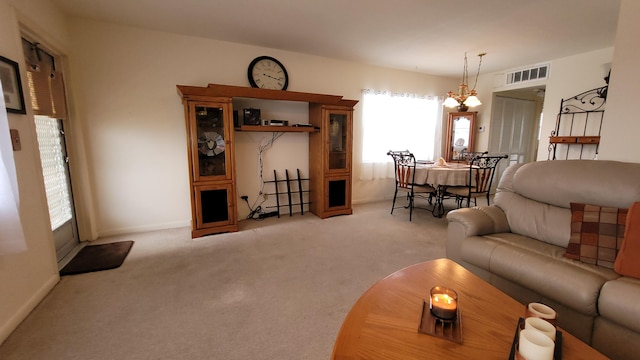 living room with an inviting chandelier and light colored carpet