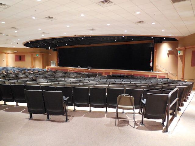 interior space featuring a paneled ceiling and light colored carpet