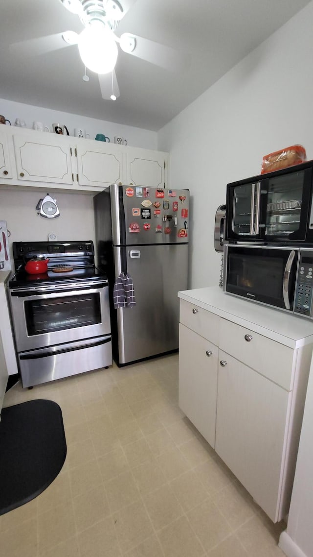 kitchen with light tile floors, stainless steel appliances, ceiling fan, and white cabinetry