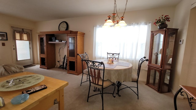 carpeted dining room featuring a chandelier and a wealth of natural light