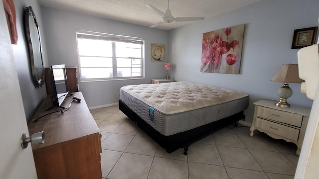 bedroom with light tile floors, a textured ceiling, and ceiling fan