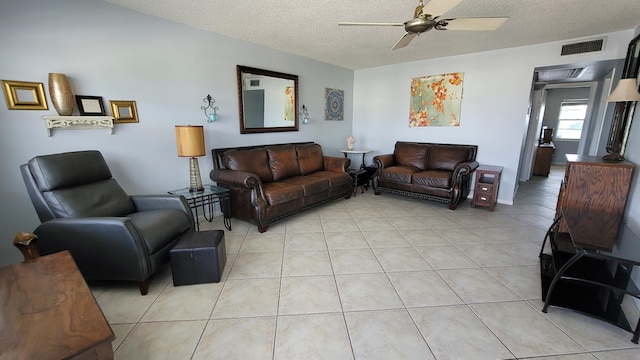 tiled living room with ceiling fan and a textured ceiling