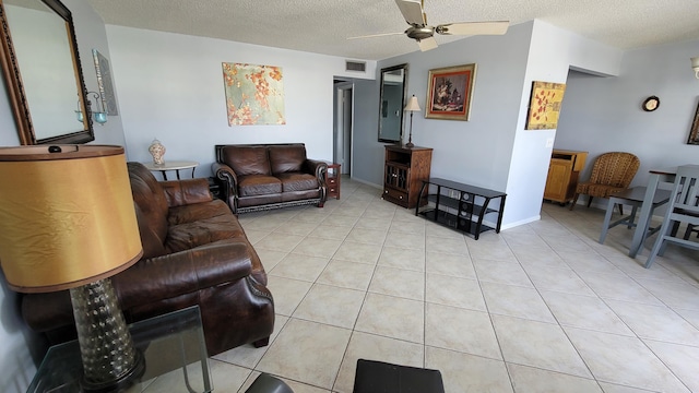 tiled living room with a textured ceiling and ceiling fan