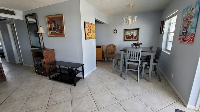 tiled dining room featuring a notable chandelier and a textured ceiling