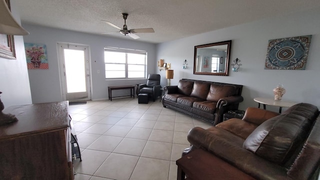 tiled living room with ceiling fan and a textured ceiling