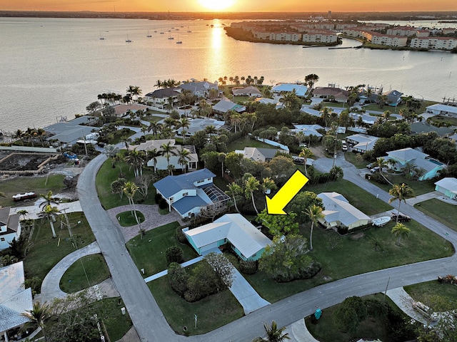 aerial view at dusk featuring a water view