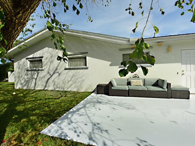 view of side of home featuring a patio, a yard, and an outdoor living space