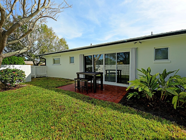 rear view of property with a lawn and a patio