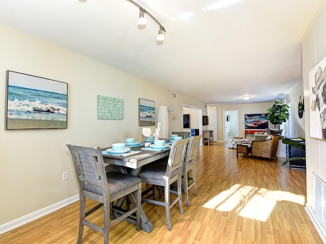 dining room featuring light wood-type flooring and rail lighting