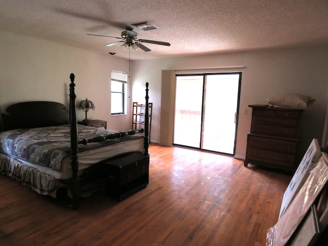 bedroom with hardwood / wood-style floors, a textured ceiling, access to outside, and ceiling fan