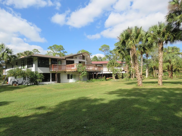 view of yard featuring a sunroom and a deck