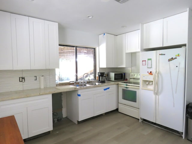 kitchen featuring white cabinetry, wood-type flooring, white appliances, and sink