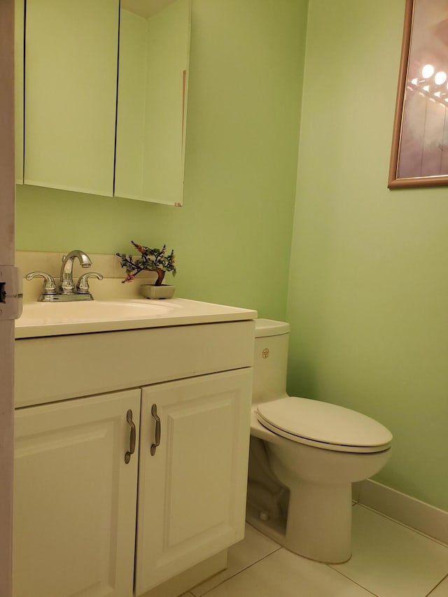 bathroom featuring toilet, tile flooring, and vanity