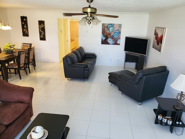 tiled living room featuring ornamental molding and ceiling fan with notable chandelier