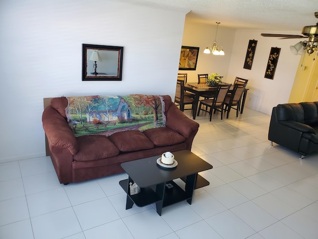 living room featuring a textured ceiling, ceiling fan with notable chandelier, and light tile floors