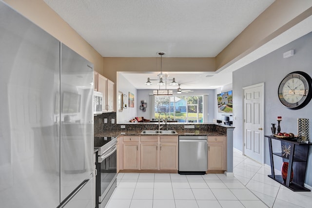 kitchen with sink, light brown cabinets, hanging light fixtures, and appliances with stainless steel finishes