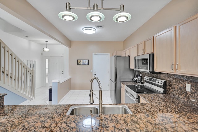 kitchen featuring decorative backsplash, light brown cabinetry, appliances with stainless steel finishes, a sink, and tile patterned flooring