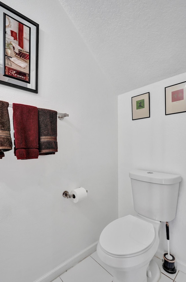 bathroom featuring vaulted ceiling, tile patterned floors, a textured ceiling, and toilet