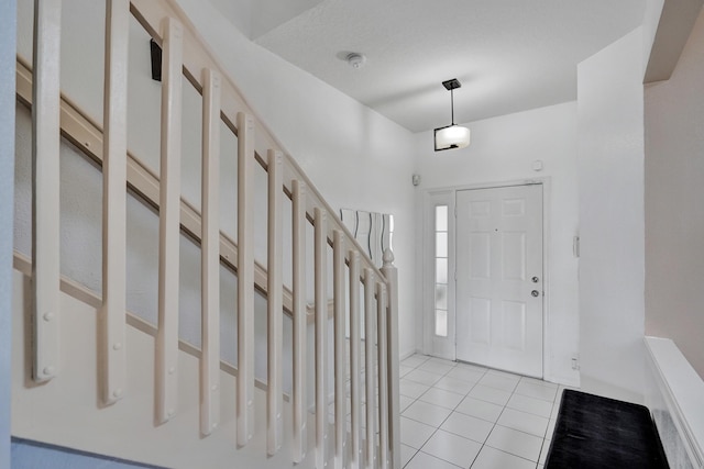 entrance foyer featuring stairway and light tile patterned floors