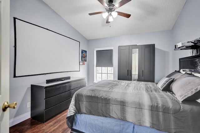 bedroom with vaulted ceiling, dark wood-style flooring, a ceiling fan, and baseboards