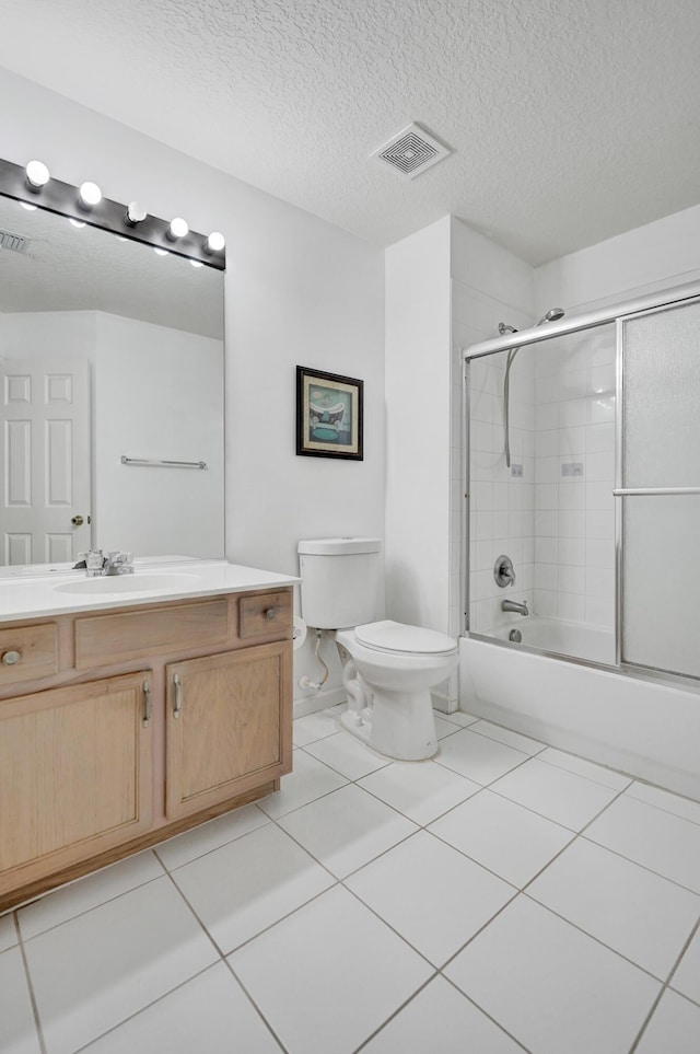 full bath featuring a textured ceiling, toilet, vanity, visible vents, and tile patterned floors