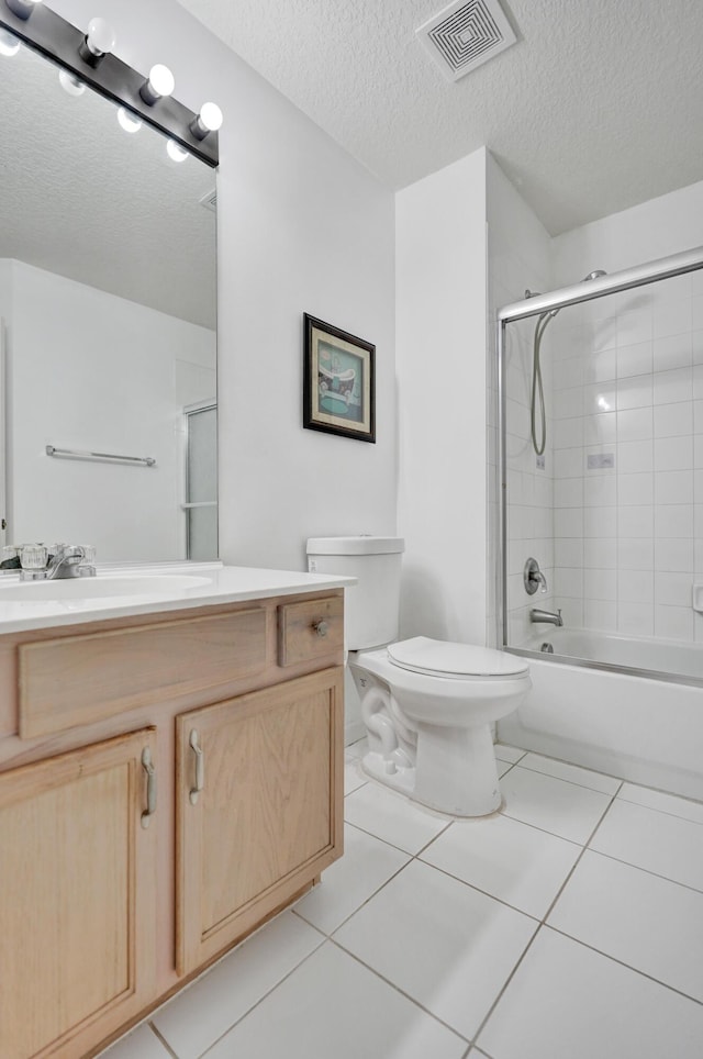 bathroom with visible vents, toilet, vanity, a textured ceiling, and tile patterned flooring