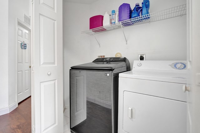 laundry area with independent washer and dryer, wood finished floors, and baseboards