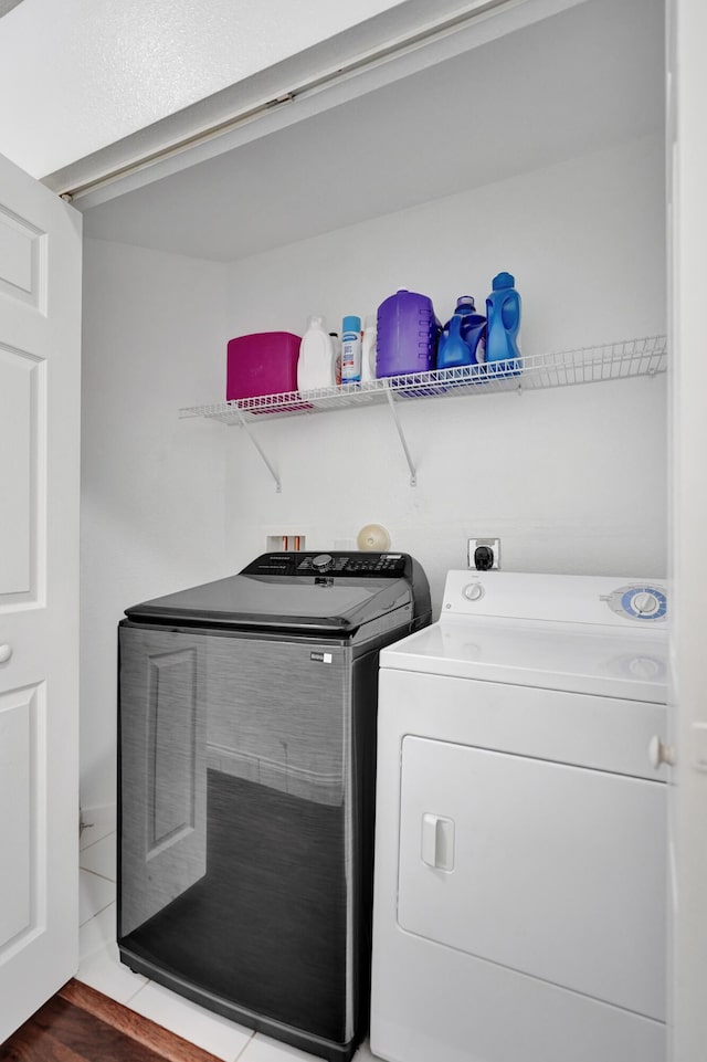 laundry area featuring laundry area, wood finished floors, and washing machine and dryer