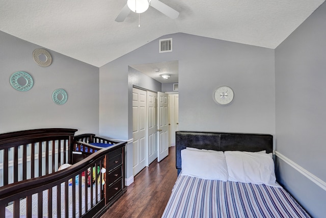 bedroom with ceiling fan, wood finished floors, visible vents, vaulted ceiling, and a closet