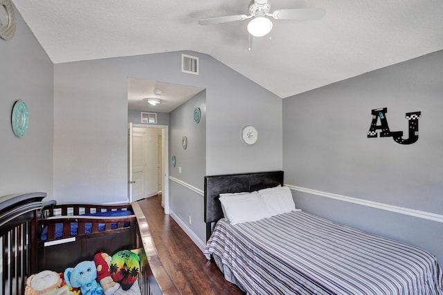 bedroom with vaulted ceiling, wood finished floors, visible vents, and baseboards