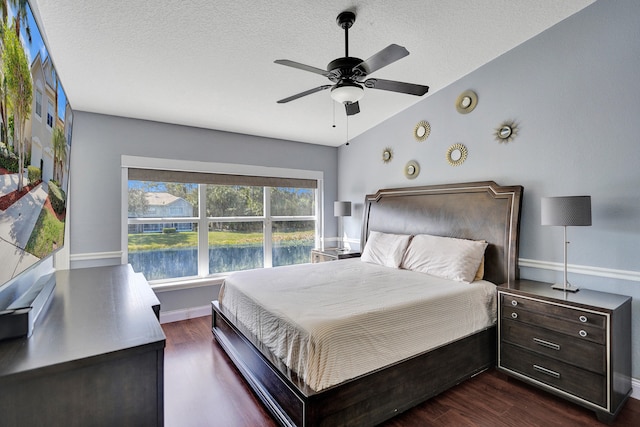 bedroom with baseboards, a ceiling fan, dark wood-style flooring, vaulted ceiling, and a textured ceiling