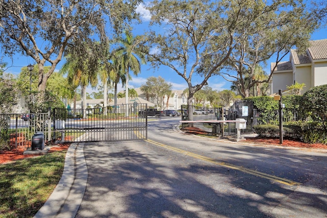 view of road featuring a gate, curbs, and a gated entry