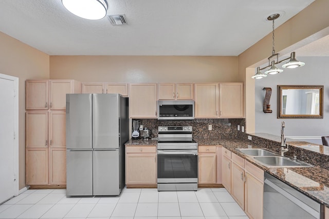 kitchen with appliances with stainless steel finishes, pendant lighting, light brown cabinetry, sink, and backsplash