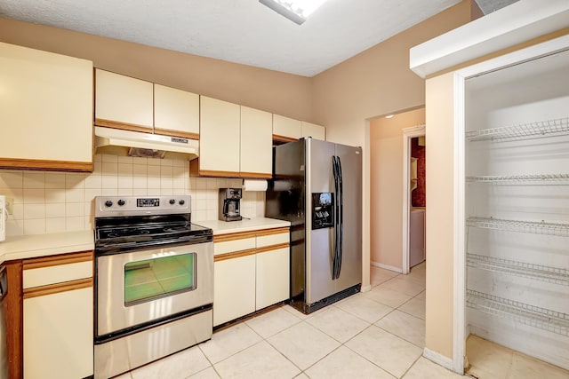 kitchen featuring light tile floors, appliances with stainless steel finishes, backsplash, and washer / clothes dryer