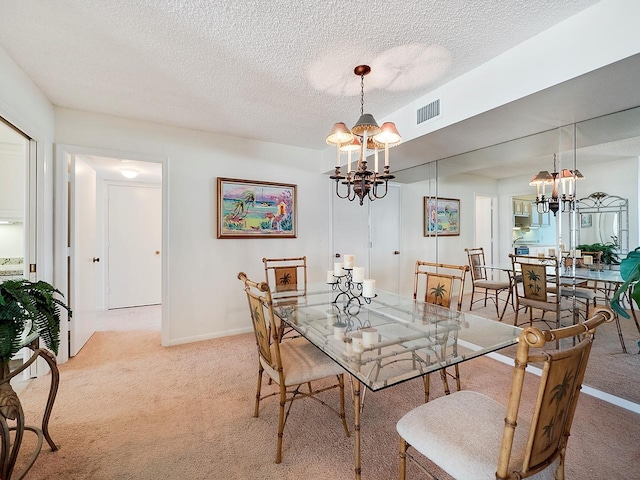 dining space featuring a textured ceiling, a notable chandelier, and light colored carpet