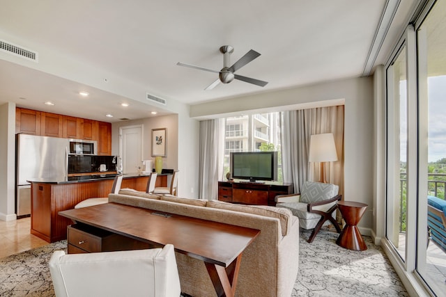 living room featuring ceiling fan and plenty of natural light