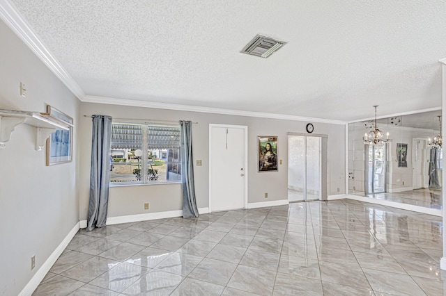 foyer entrance featuring an inviting chandelier, ornamental molding, a textured ceiling, and light tile floors