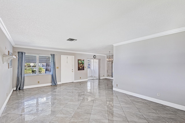 tiled empty room featuring an inviting chandelier, a textured ceiling, and ornamental molding