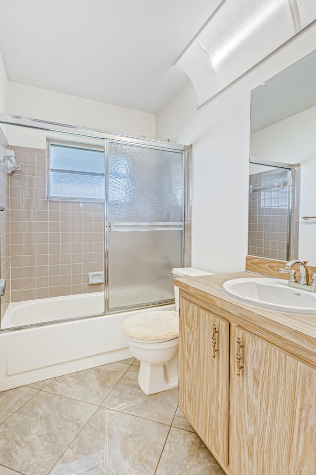 full bathroom with enclosed tub / shower combo, toilet, tile floors, and vanity