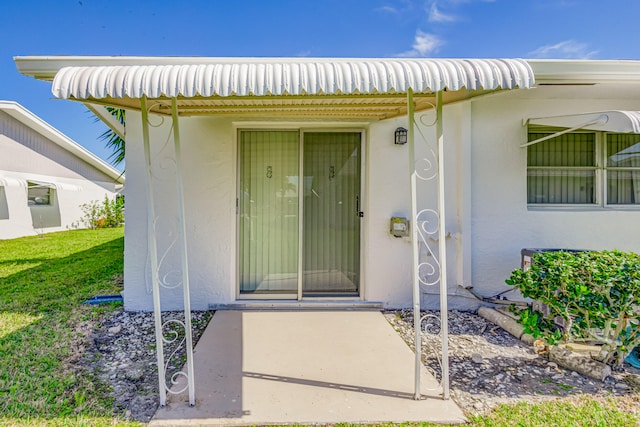 entrance to property with a lawn