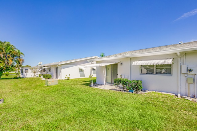 rear view of property with a yard