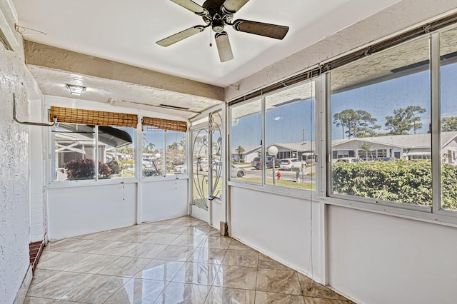 unfurnished sunroom with ceiling fan and a healthy amount of sunlight