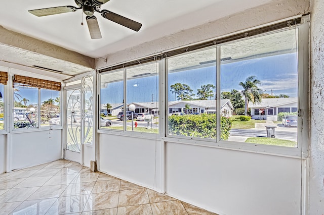 unfurnished sunroom with ceiling fan