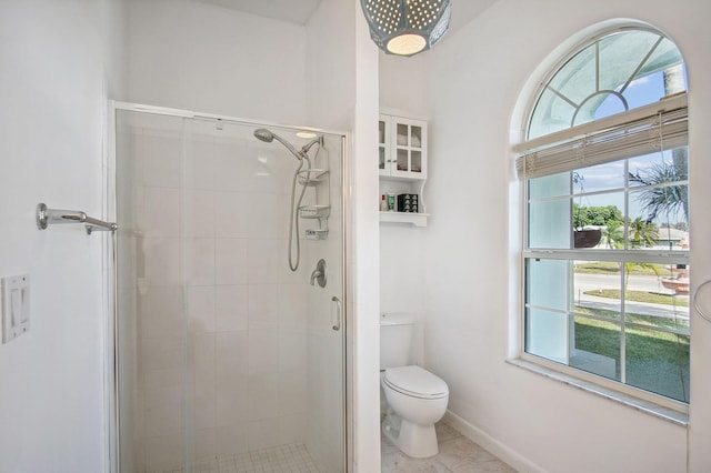 bathroom with toilet, an enclosed shower, and a wealth of natural light