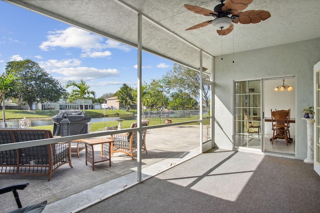 unfurnished sunroom with a water view and ceiling fan with notable chandelier