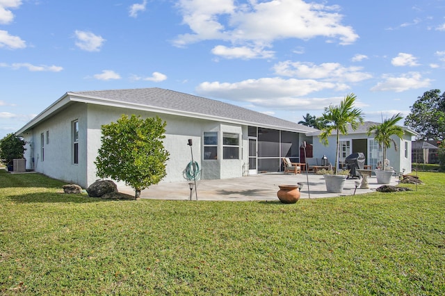 rear view of property with a yard, central air condition unit, a fire pit, and a patio