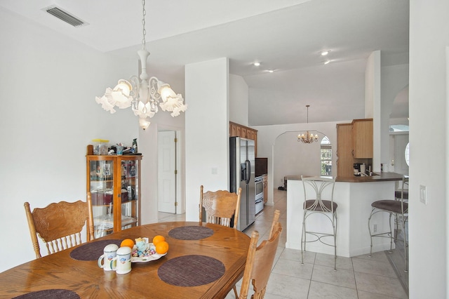 dining room featuring high vaulted ceiling, an inviting chandelier, and light tile floors